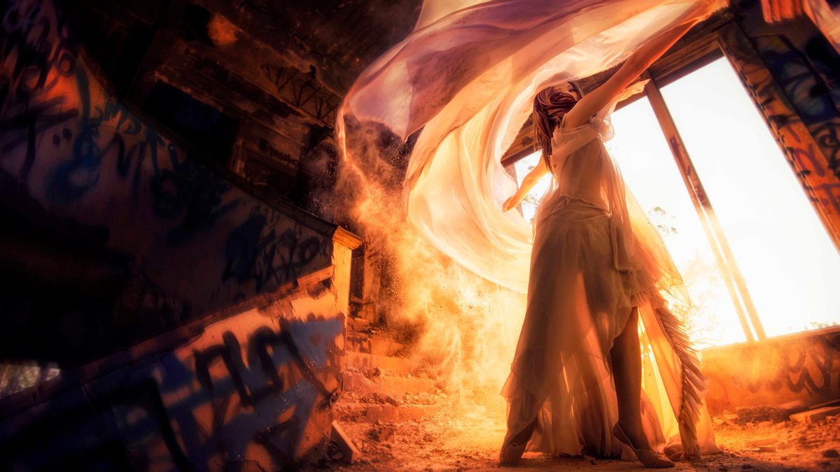 A surreal photo taken by Martin Wong of a woman moving dynamically during golden hour.